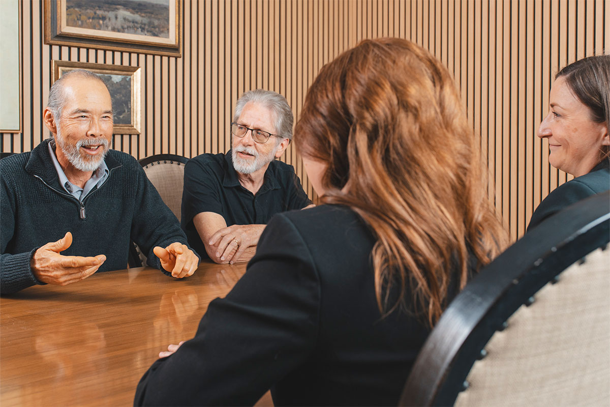 Two attorneys help two men establish wills and trusts in Rocklin and Roseville while in a conference room.